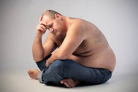 Мужчина с лишним весом сидит